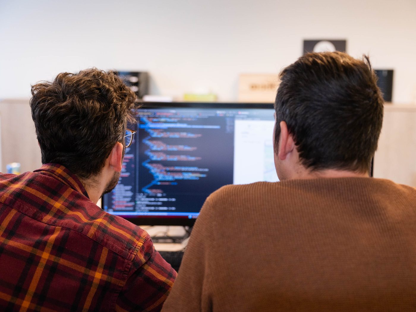 Twee Axxit-ontwikkelaars die samen aan een systeem werken